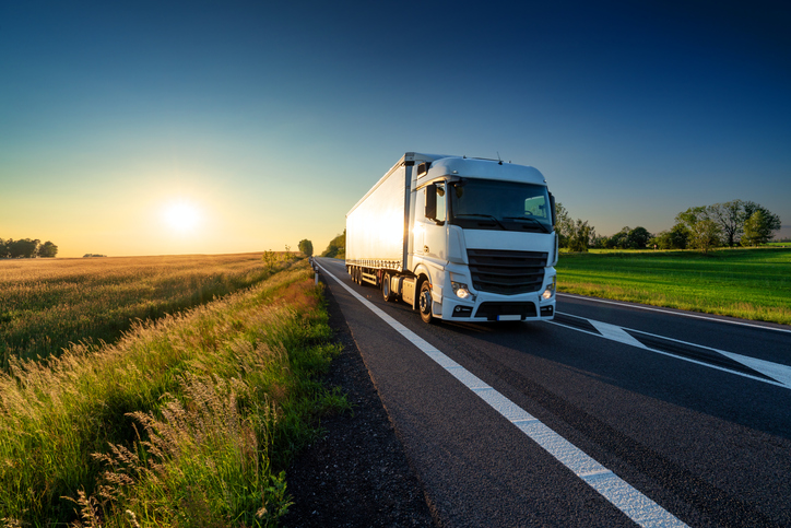 Caminhão em rodovia ao entardecer, representando a operação de transporte da Rodonorte